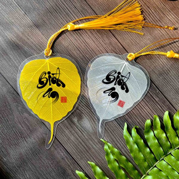 Gold and white Bodhi leaf bookmarks with Vietnamese calligraphy and tassels