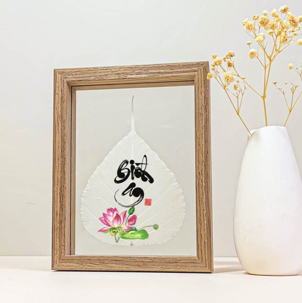 Pink lotus and Bình An calligraphy printed on a Bodhi leaf in a wood desk frame